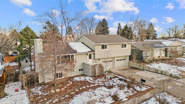 snow covered property with a garage