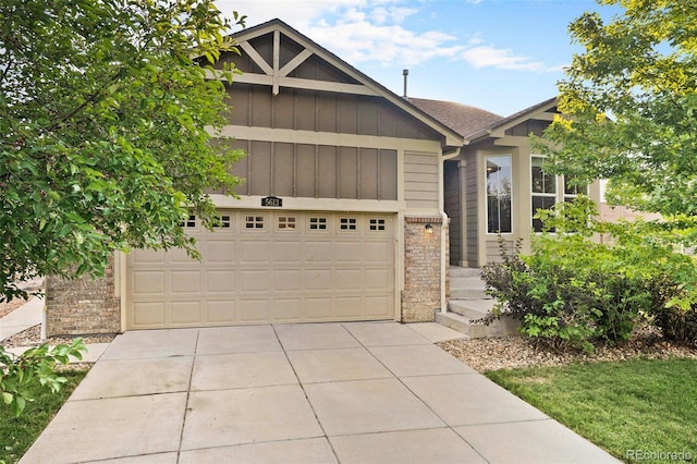 view of front facade featuring driveway, a garage, board and batten siding, and brick siding