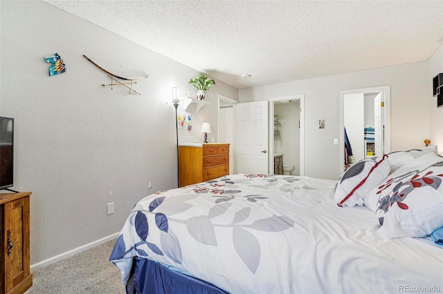 bedroom with a closet, carpet flooring, a textured ceiling, and ensuite bath