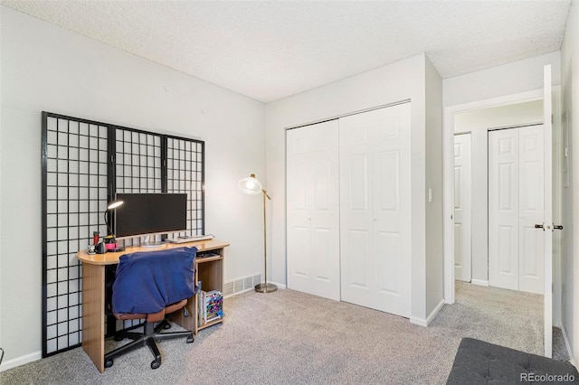 office featuring light colored carpet and a textured ceiling