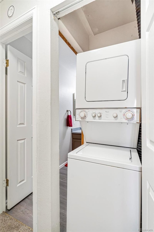 clothes washing area with stacked washer / drying machine and light hardwood / wood-style floors