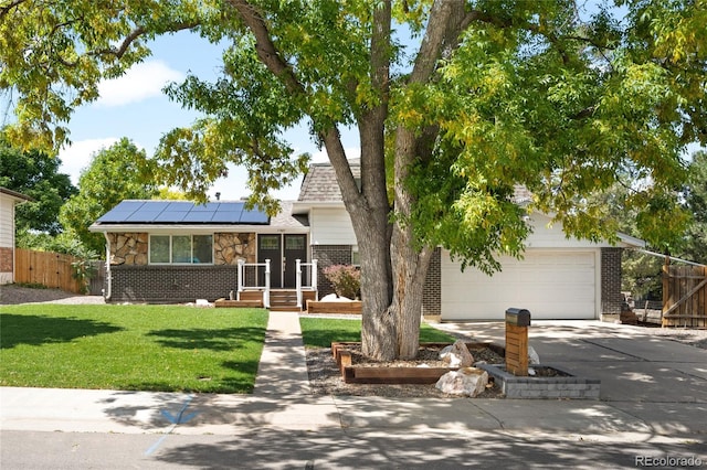 view of front of home with solar panels, a garage, and a front yard