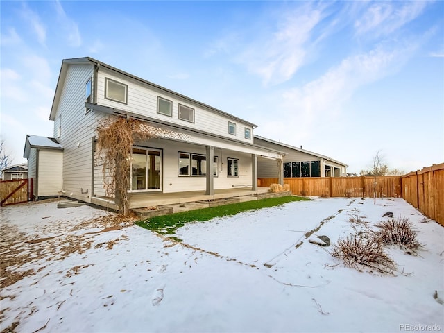 snow covered property featuring a fenced backyard