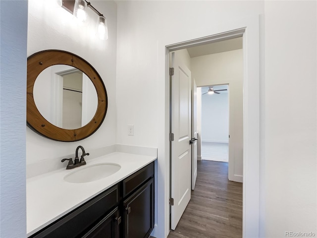 bathroom featuring baseboards, wood finished floors, and vanity