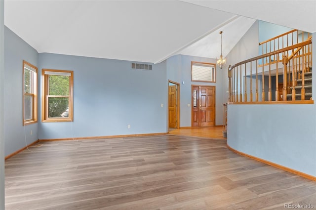 empty room with baseboards, stairs, wood finished floors, and a notable chandelier