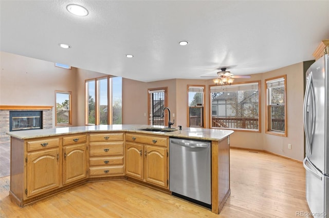 kitchen with a ceiling fan, appliances with stainless steel finishes, a sink, light wood finished floors, and recessed lighting