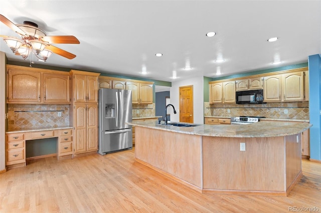 kitchen with ceiling fan, tasteful backsplash, a spacious island, a sink, and stainless steel appliances