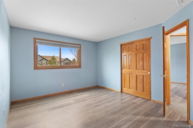 unfurnished bedroom with baseboards and wood finished floors