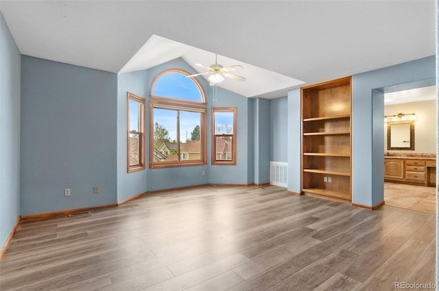 unfurnished living room featuring a ceiling fan, visible vents, built in features, wood finished floors, and lofted ceiling