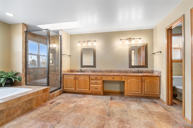 bathroom featuring toilet, a wealth of natural light, a sink, and a stall shower