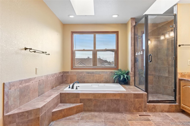 full bath featuring a skylight, visible vents, a garden tub, and a stall shower