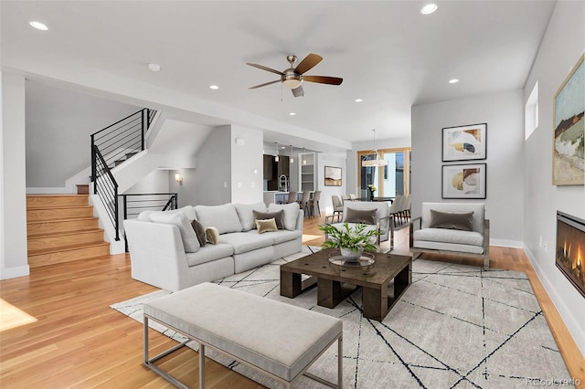 living room with light hardwood / wood-style floors and ceiling fan