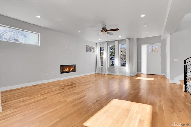 unfurnished living room with ceiling fan, plenty of natural light, and light wood-type flooring