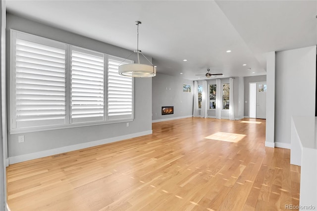 unfurnished living room with ceiling fan, plenty of natural light, and light hardwood / wood-style floors