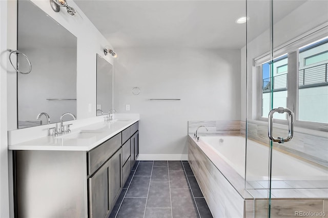 bathroom with vanity, tile patterned flooring, and a relaxing tiled tub