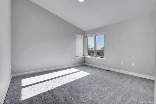 unfurnished room with carpet floors and vaulted ceiling