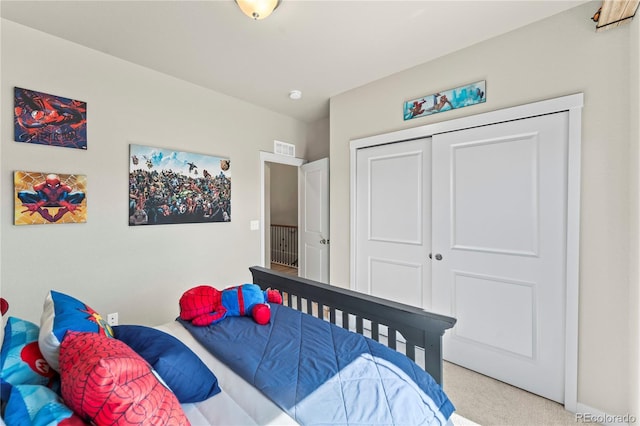 carpeted bedroom with visible vents and a closet