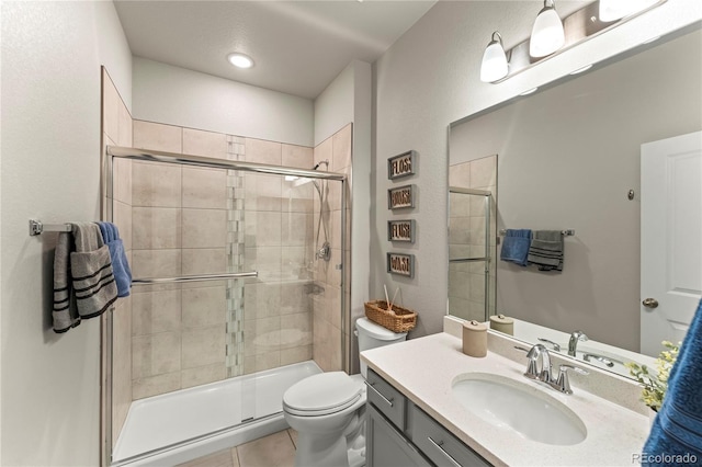 bathroom with toilet, a stall shower, tile patterned floors, and vanity