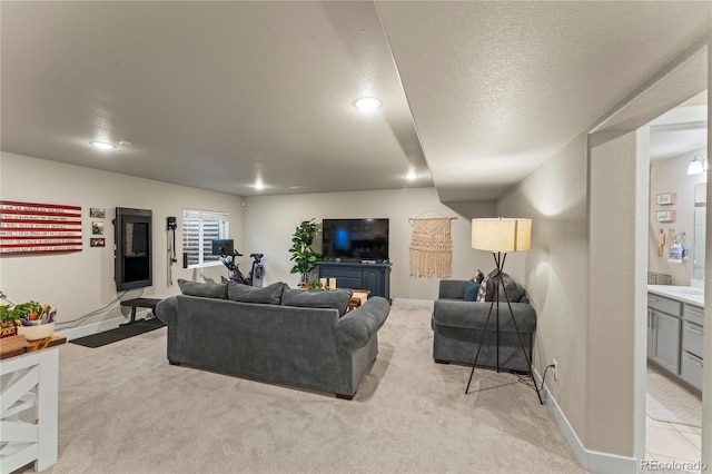 living room with recessed lighting, light carpet, a textured ceiling, and baseboards