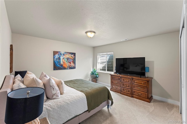 carpeted bedroom featuring visible vents, a textured ceiling, and baseboards