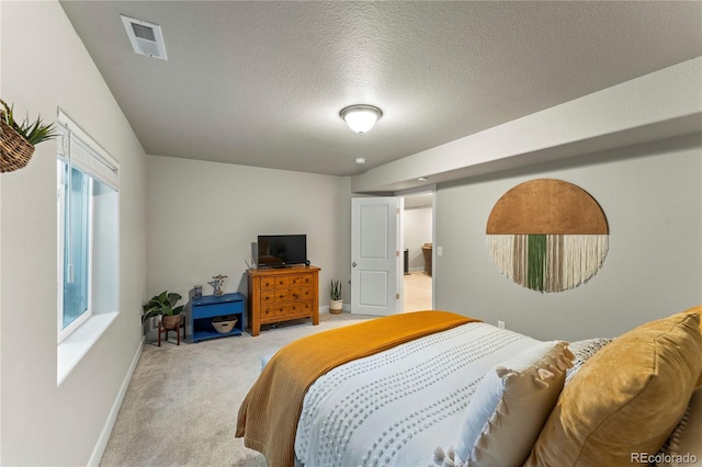 carpeted bedroom featuring visible vents, a textured ceiling, and baseboards