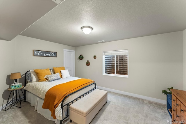 bedroom with carpet floors, visible vents, a textured ceiling, and baseboards