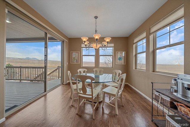 dining area featuring a mountain view, hardwood / wood-style floors, and an inviting chandelier