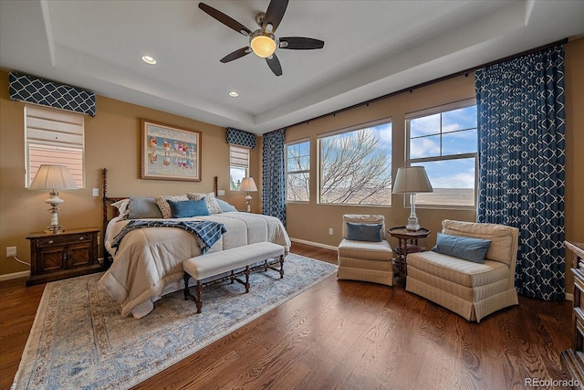 bedroom featuring dark wood-type flooring, ceiling fan, and a raised ceiling