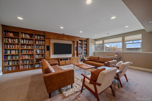 living room with built in shelves, a textured ceiling, and carpet flooring