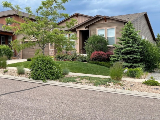 craftsman house with a garage and a front lawn