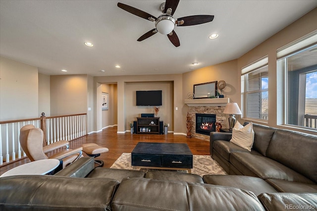 living room with a fireplace, wood-type flooring, and ceiling fan