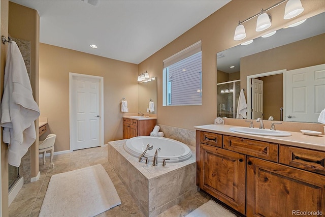 bathroom featuring a stall shower, two vanities, a sink, and a bath