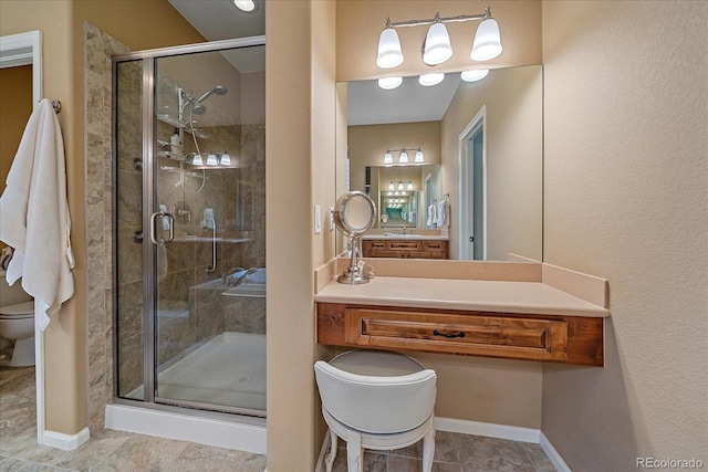 bathroom featuring walk in shower, vanity, toilet, and tile patterned flooring