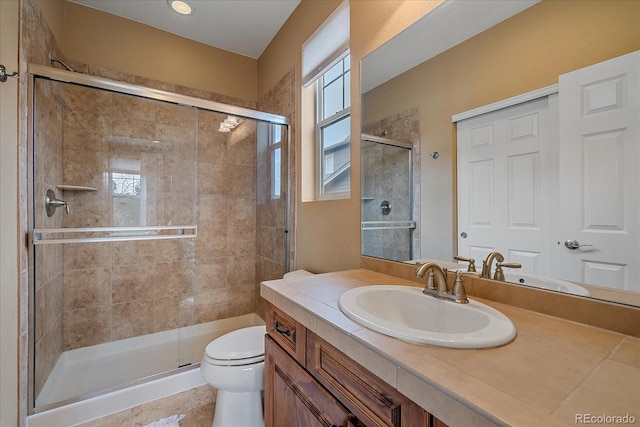 bathroom featuring a shower stall, vanity, and toilet