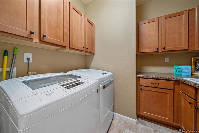 washroom featuring separate washer and dryer and cabinets