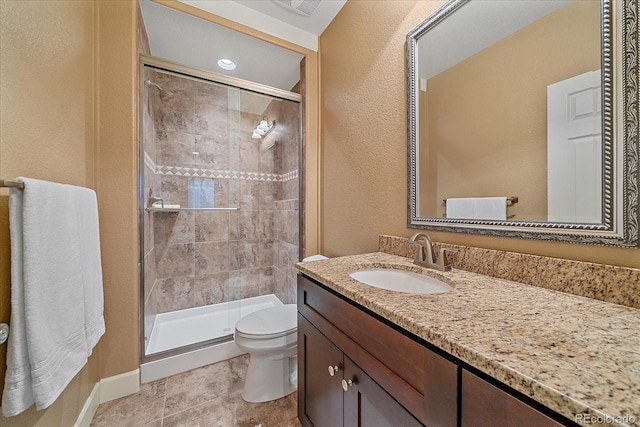 bathroom featuring baseboards, toilet, a shower stall, and vanity