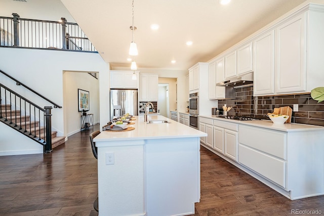 9607 Williamsburg St, Littleton, CO 80125 - kitchen featuring appliances with stainless steel finishes, tasteful backsplash, white cabinets, and recessed lighting