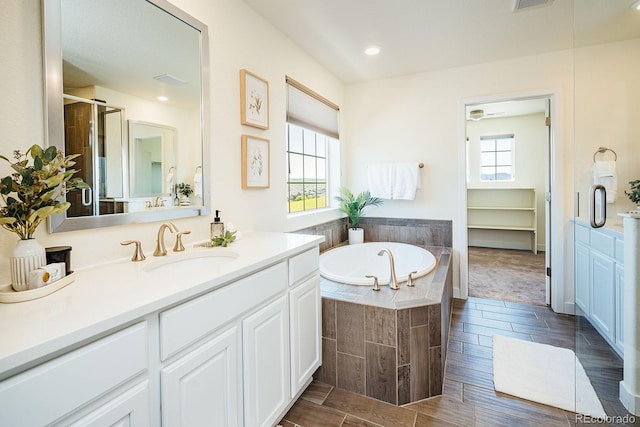 9607 Williamsburg St, Littleton, CO 80125 - full bath with vanity, a bath, a shower stall, wood finish floors, and recessed lighting