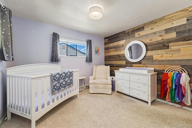 1211 S Zuni St, Denver, CO 80223 - carpeted bedroom featuring wood walls and a nursery area