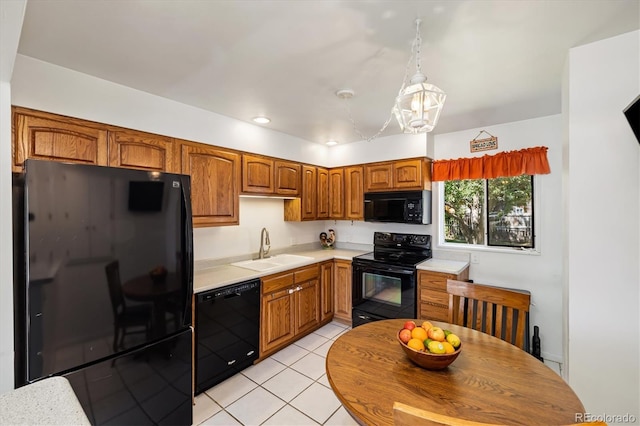 1211 S Zuni St, Denver, CO 80223 - kitchen with black appliances, a sink, light countertops, a chandelier, and light tile patterned flooring
