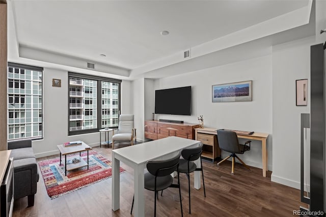 1750 Wewatta St Unit 605, Denver, CO 80202 - living area featuring dark wood-type flooring, a tray ceiling, baseboards, and a desk