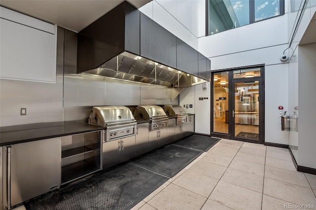 1750 Wewatta St Unit 605, Denver, CO 80202 - kitchen featuring light tile patterned floors, dark countertops, and a high ceiling