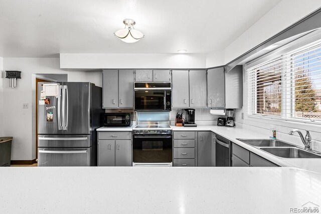 1903 Northmoor Ter, Pueblo, CO 81008 - kitchen with gray cabinets, stainless steel appliances, a sink, light countertops, and decorative backsplash