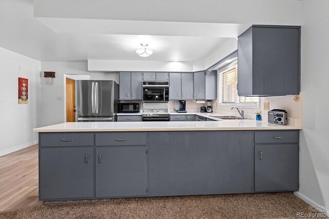 1903 Northmoor Ter, Pueblo, CO 81008 - kitchen with stainless steel appliances, gray cabinetry, a sink, and a peninsula