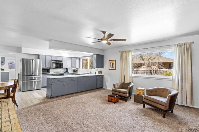 1903 Northmoor Ter, Pueblo, CO 81008 - kitchen featuring stainless steel appliances, gray cabinetry, a peninsula, a ceiling fan, and light countertops