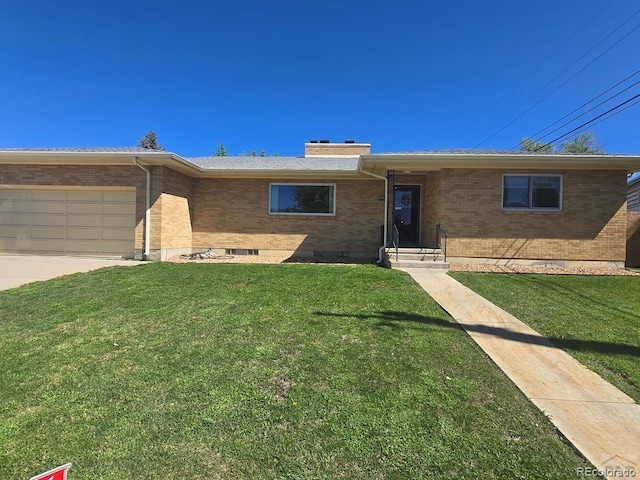 1903 Northmoor Ter, Pueblo, CO 81008 - ranch-style house with brick siding, a front lawn, an attached garage, a chimney, and driveway