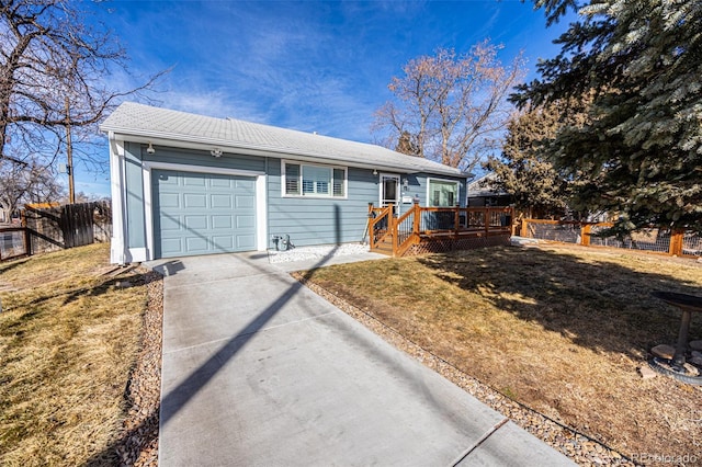 ranch-style house featuring a garage, concrete driveway, fence, and a front lawn