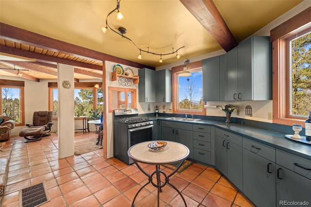174 Needle Creek Rd, Divide, CO 80814 - kitchen featuring stainless steel range with gas cooktop, a sink, beam ceiling, dark countertops, and light tile patterned flooring