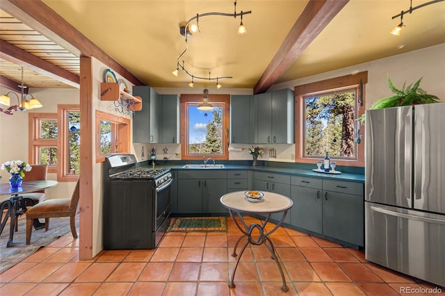 174 Needle Creek Rd, Divide, CO 80814 - kitchen featuring stainless steel appliances, a sink, dark countertops, beam ceiling, and light tile patterned floors