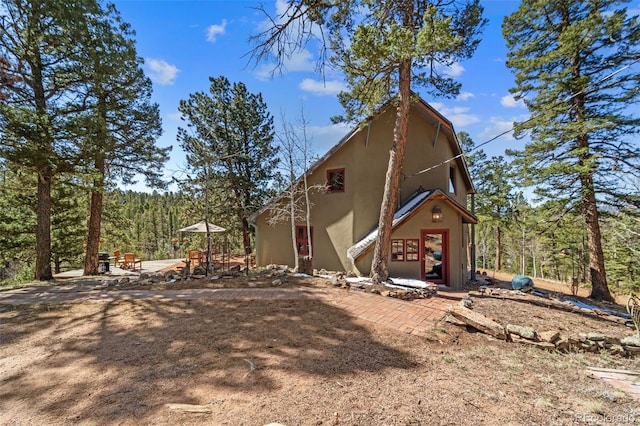 174 Needle Creek Rd, Divide, CO 80814 - back of house featuring stucco siding and a view of trees